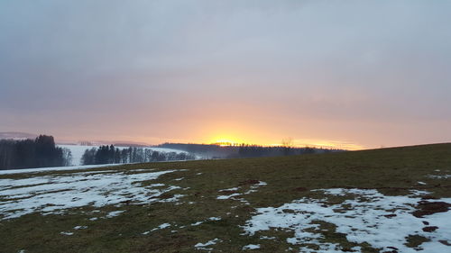 Scenic view of snow field against sky during sunset