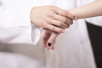Midsection of doctor examining hand