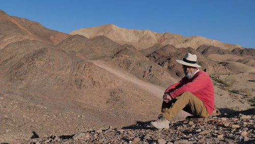 Senior man sitting in the desert 