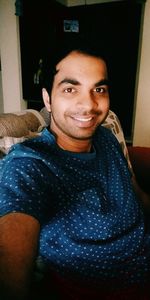 Portrait of smiling young man sitting at home