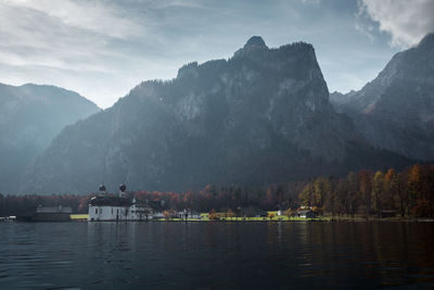 Scenic view of lake by mountains against sky