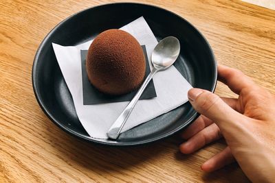 High angle view of hand holding ice cream on table