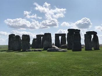 Stone wall on field against sky