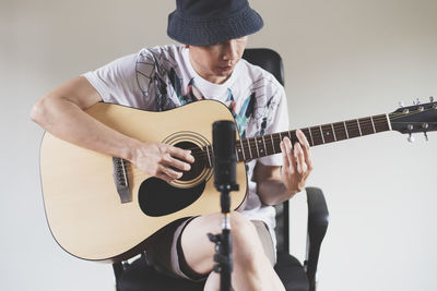 Man playing guitar against white background