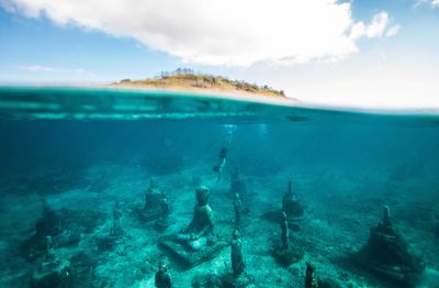 Divers take care of the buddha statue under the sea.