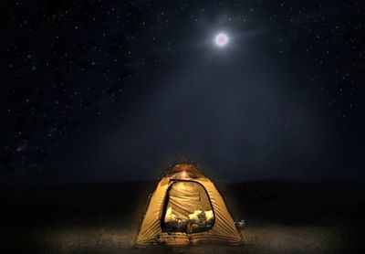 Low angle view of illuminated light against sky at night
