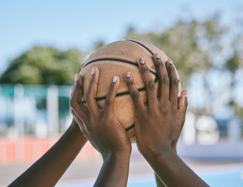 Cropped hand of man playing basketball