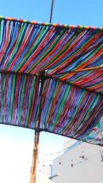 Low angle view of multi colored umbrellas against sky