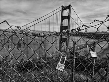 View of suspension bridge against cloudy sky