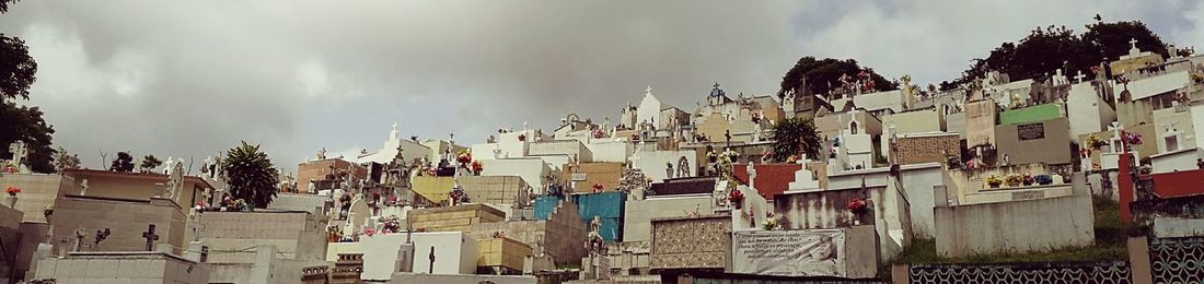 Panoramic shot of buildings against cloudy sky