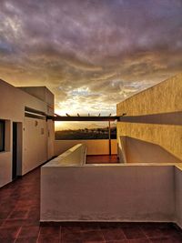 Building by sea against sky during sunset