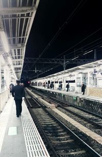 Man walking on railroad station platform at night