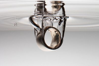 Close-up of ring underwater against white background