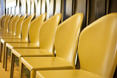 Empty yellow chairs arranged in row