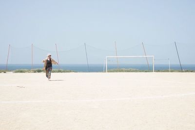 Man on beach against clear sky