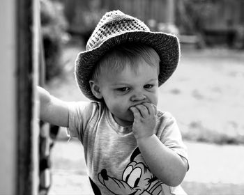 Cute boy wearing hat standing outdoors
