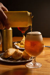 Close-up of hand holding wineglass on table