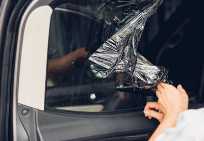 Midsection of person cleaning car window