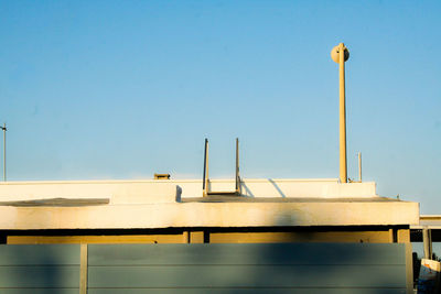 Low angle view of industry against clear blue sky