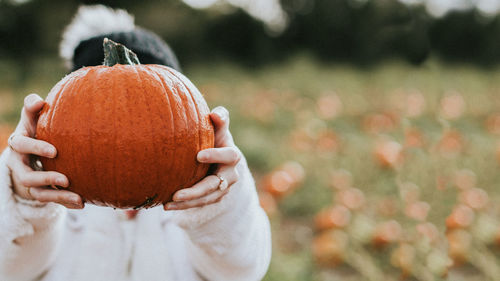 Midsection of man holding pumpkin