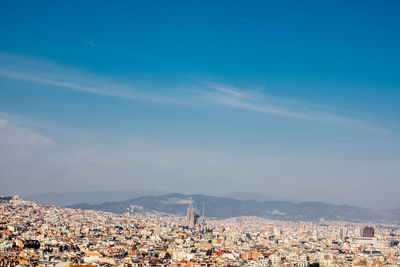 Aerial view of townscape by mountain against sky