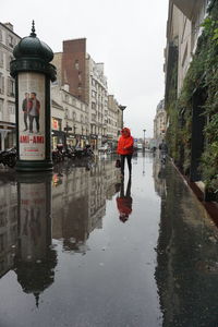 Reflection of man walking in puddle