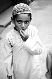 High angle portrait of boy wearing traditional clothing standing on street