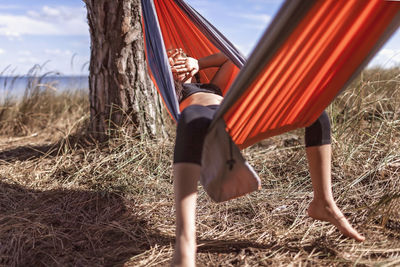 Full length of man sitting on hammock at field