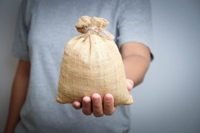 Midsection of man holding jute sack