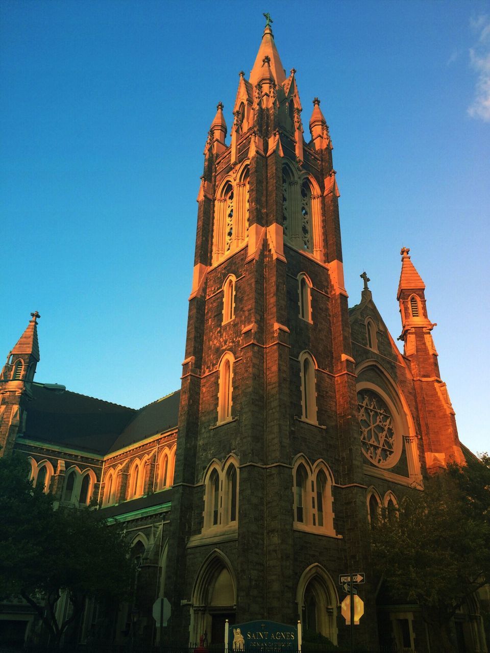 religion, building exterior, architecture, place of worship, church, built structure, spirituality, low angle view, clear sky, blue, cathedral, sky, tower, clock tower, cross, steeple, no people, history