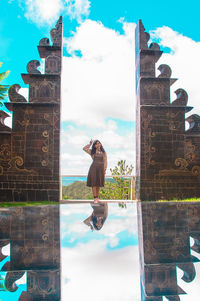 Woman on cross against sky