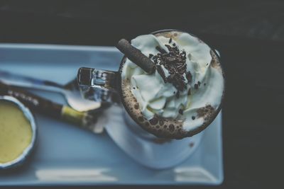 High angle view of hot chocolate with whipped cream in glass on table