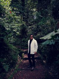 Full length of young man standing in forest