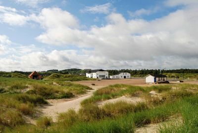 Houses on field against sky