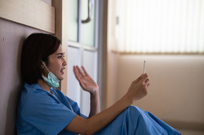 Side view of young woman using smart phone