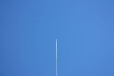 Low angle view of vapor trail against blue sky