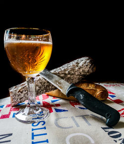 Close-up of beer glass on table against black background