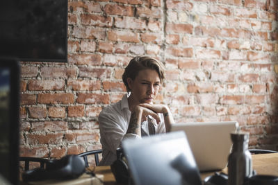 Female hacker working on laptop at creative office