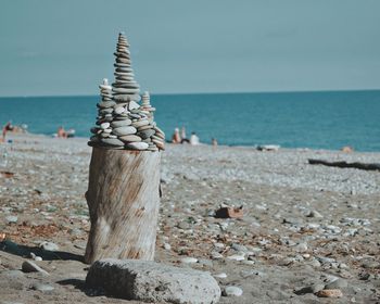 Stack of pebbles on beach against sky