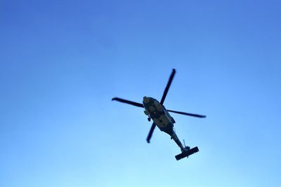 Low angle view of airplane against clear blue sky