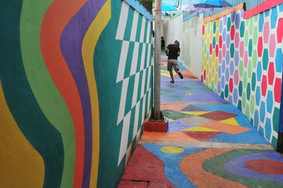 Full length of woman on multi colored graffiti on wall