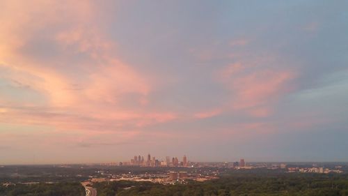 Aerial view of city against cloudy sky
