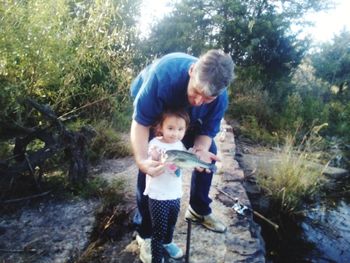 Father and son on tree by plants