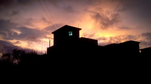 Silhouette buildings against sky during sunset