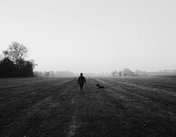 Full length of woman walking on road against clear sky