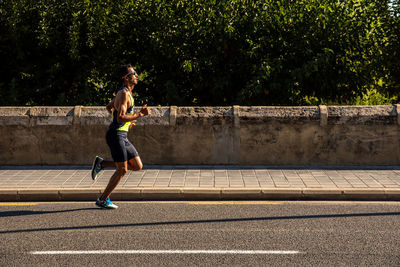 Full length of man running on footpath