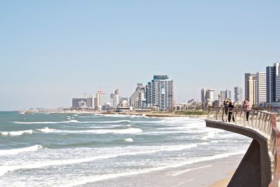 Panoramic view of beach and city against clear sky