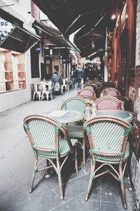 People sitting at sidewalk cafe against buildings in city