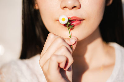 Close-up of woman holding pink flower