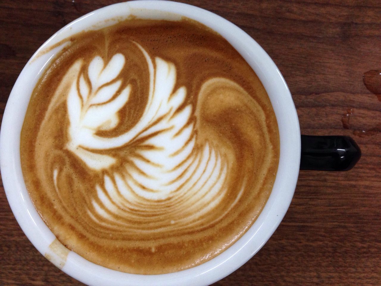 coffee cup, coffee - drink, froth art, refreshment, drink, food and drink, cappuccino, frothy drink, saucer, table, indoors, still life, coffee, high angle view, close-up, freshness, latte, directly above, creativity, art